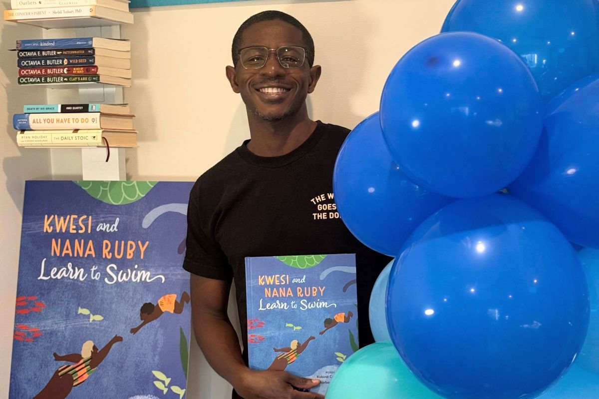 Author holding up his book: "Kwesi and Nana Ruby Learn to Swim"