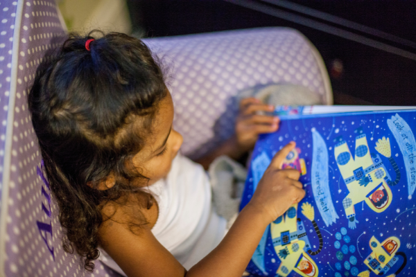 Young girl opening a Barefoot book